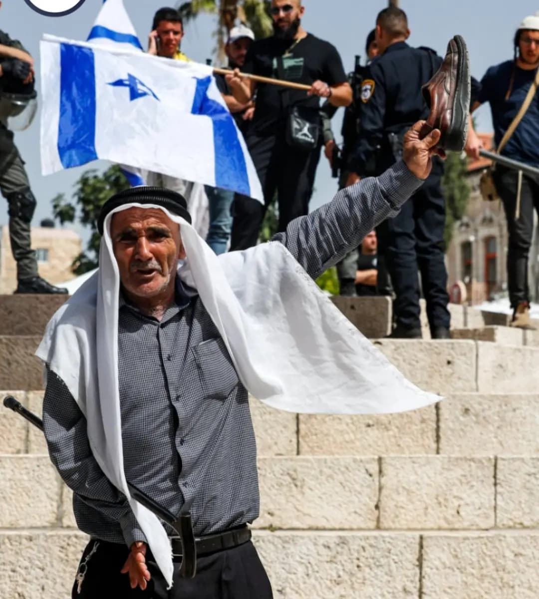 ‏مسن فلسطيني يرفع حذاءه في وجه إسرائيليين بمنطقة باب العامود في القدس مع تصاعد التوترات عشية مسيرة الأعلام التي سينظمها المستوطنون